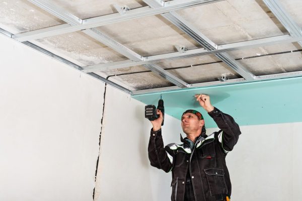 construction-worker-assembly-suspended-ceiling-with-drywall-fixing-drywall-ceiling-metal-frame-with-screwdriver_166373-1913